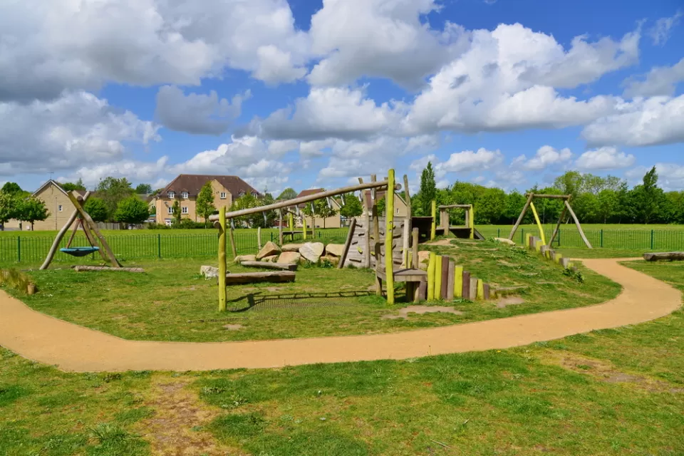 Children's playground in a London park with a green lawn